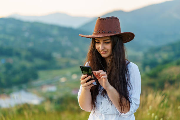 istock Happy Cow Girl using mobile in mountain for texting 1265032261