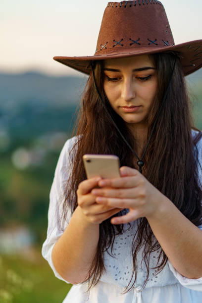 istock Happy Cow Girl using mobile in mountain for texting 1265032306