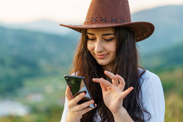 istock Happy Cow Girl using mobile in mountain for texting 1265032416