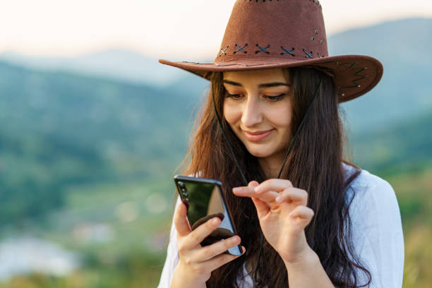 istock Happy Cow Girl using mobile in mountain for texting 1265032417