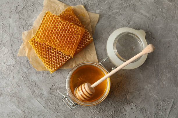 istock Composition with honeycombs, honey and dipper on gray background 1265032510