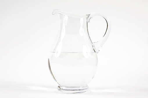 Fresh water with ice in decanter on white background