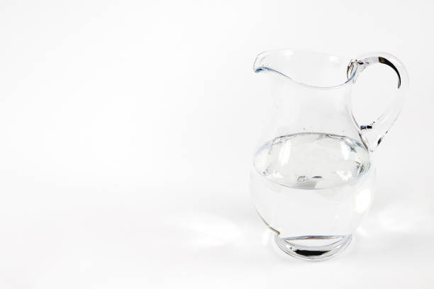 Fresh water with ice in decanter on white background