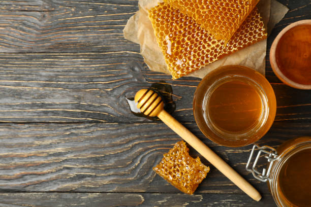 istock Honeycombs, jar with honey and dipper on wooden background 1265033464
