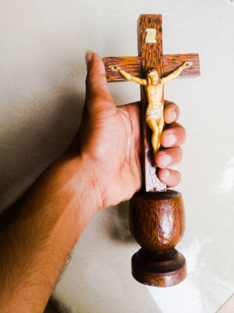 Holy cross in a white background.with god jesus hanging on it.The God jesus who got crucified in the cross is shown. A holy cross with god jesus on it holding in a hand.Fingers have grabbed the cross around it. what mountain was jesus crucified on stock pictures, royalty-free photos & images