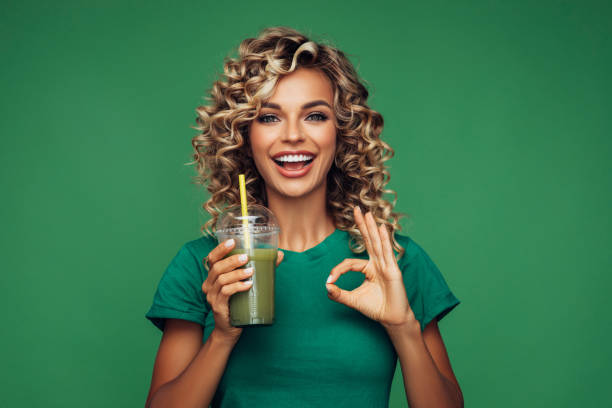 istock Beautiful woman drinking smoothie 1265034275