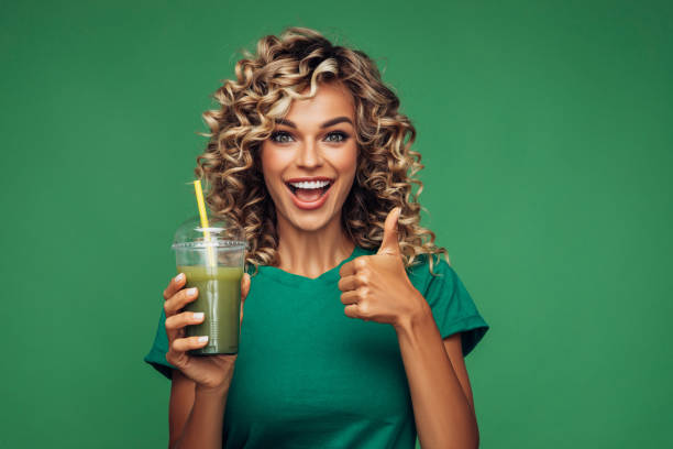 istock Beautiful woman drinking smoothie 1265034386