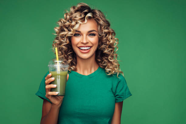 istock Beautiful woman drinking smoothie 1265034435