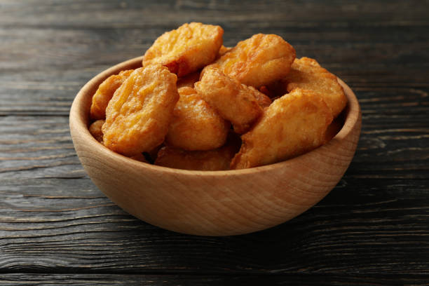istock Bowl with fried chicken nuggets on wooden background 1265035374