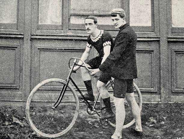 istock Cyclist portrait, sitting on the bicycle, is held by another man 1265036423