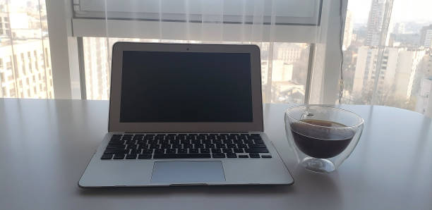 istock Still-life portrait of grey computer with black buttons, coffee mug on table 1265036481