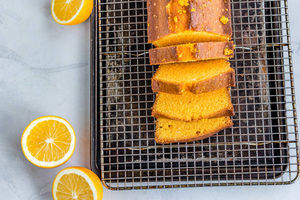 istock Orange Pound Cake  and Slices in a Baking Sheet on White Background Top Down Flat Lay horizontal Photo 1265037846