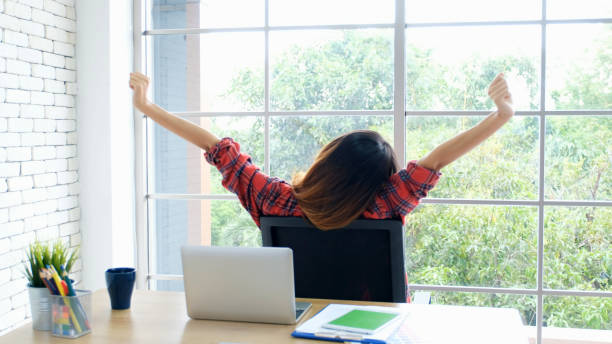 istock Work from home, Stretch for relax, Young asian woman stretching body while working with laptop computer at her desk home office, Back of female student raised arms take rest from online education 1265038412