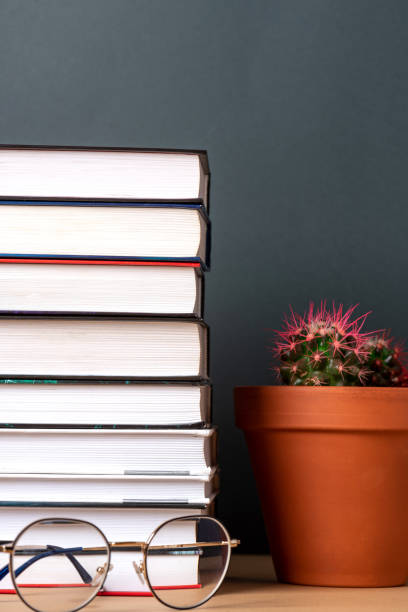 istock Stack of books and glasses on a dark background 1265038853