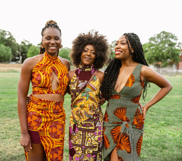Group of Young African American women feeling good while walking the field  in the park together. Urban exterior in the summer.
