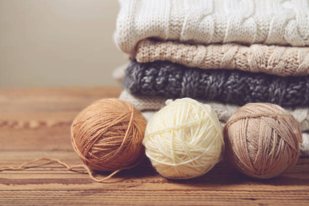 stack of sweaters on a wooden table stack of sweaters on a wooden table wool stock pictures, royalty-free photos & images