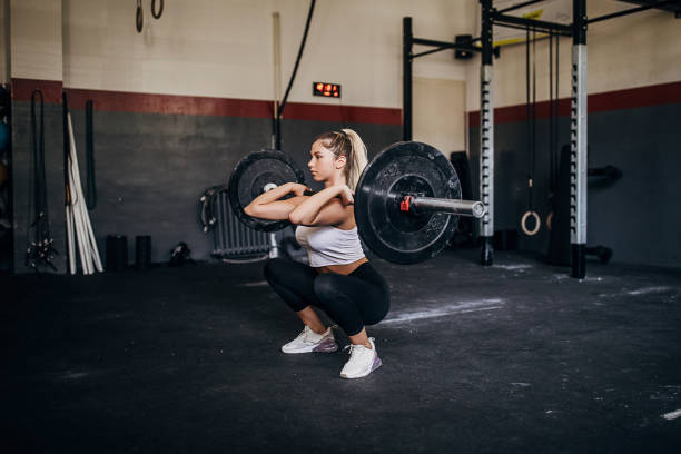 istock Sportswoman doing barbell lifting in the gym 1265040618