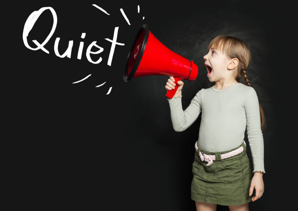 istock Cute small girl screaming through a megaphone be quiet! 1265040824