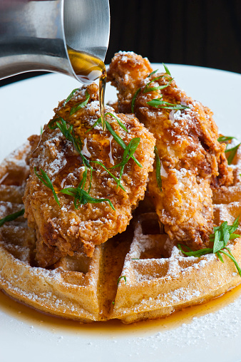 Waffles w/ fried chicken. Homemade Waffles w/ crispy chicken butter & maple syrup. Classic American breakfast or brunch favorite. Made from scratch Waffles  w/ chicken, butter & maple syrup.