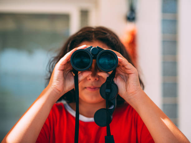 istock Cute Girl Looking With Binoculars For Exploring the City 1265044056