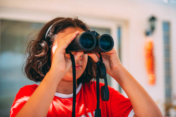 istock Cute Girl Looking With Binoculars For Exploring the City 1265044124