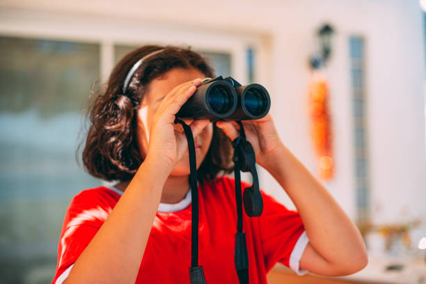 istock Cute Girl Looking With Binoculars For Exploring the City 1265044168