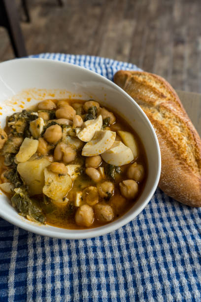 istock Chickpea stew with chard, boiled egg and potatoes on a blue checkered tablecloth 1265045496