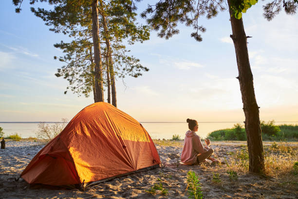 istock Charming female traveler drinking coffee on the beach 1265049368