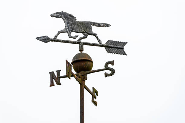 A distressed steeple with a weather vane.