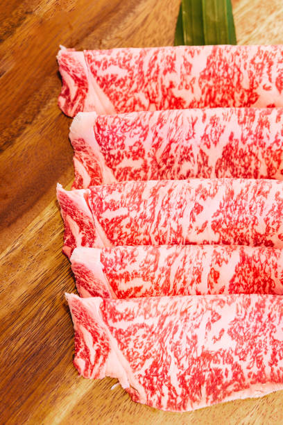 istock Premium Rare Slices Wagyu A5 beef with high-marbled texture on square wooden plate served for Sukiyaki and Shabu. 1265049607
