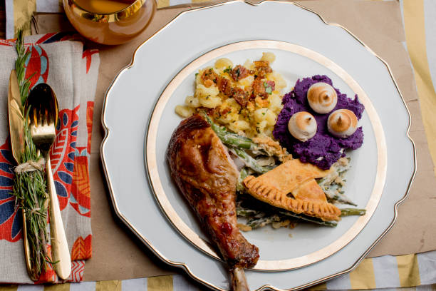 istock Thanksgiving dinner. Traditional thanksgiving dinner table with stuffed turkey, stuffing, mashed potatoes, green beans, Brussels sprouts, candied yams, ham, dinner rolls, pumpkin pie, pecan pie and red wine. Classic holiday meal. 1265051010