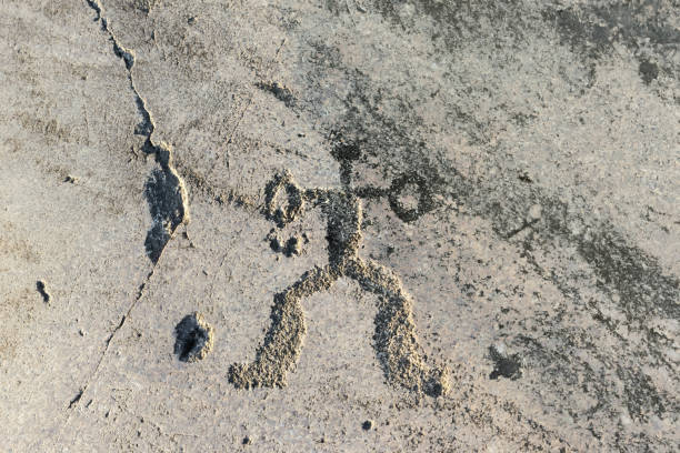 Prehistoric rock carving on the granite shore of the lake. Anthropomorphic ornament close-up - fragment of Onega petroglyphs dating back 5000-6000 years. Cape Pery Nos, Republic of Karelia, Russia.