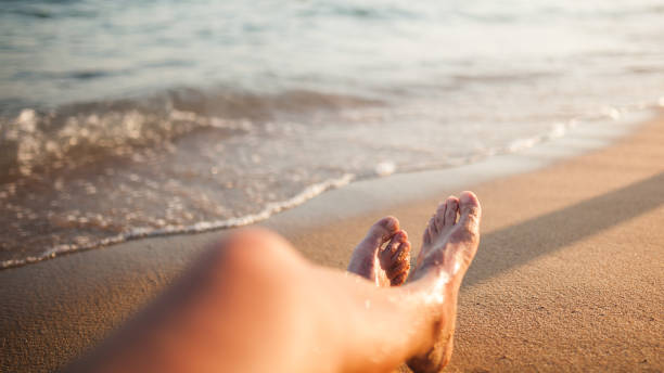 istock Young man’s legs on the sands by the sea 1265052625