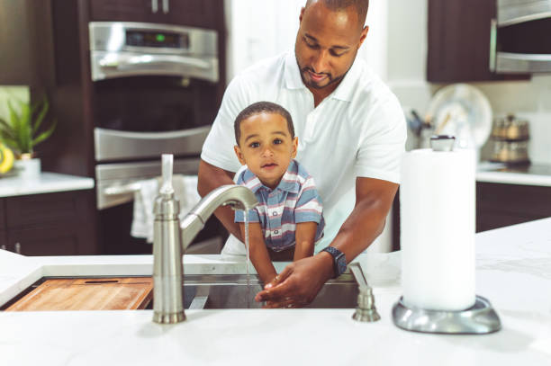 istock African American father helps his son wash his hands 1265053668