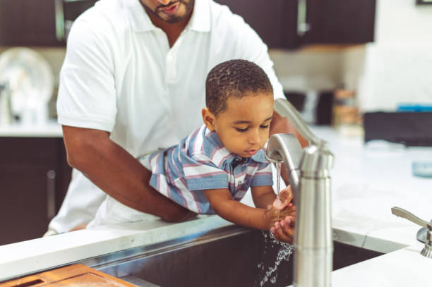 istock African American father helps his son wash his hands 1265053711