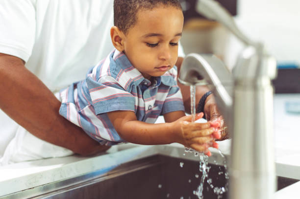 istock African American father helps his son wash his hands 1265053754