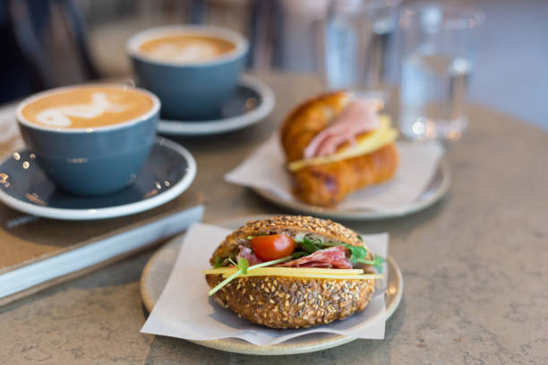Two cups of cappuccino with latte art, sandwich and croissant on marble background. Concept of easy breakfast. Gray ceramic cups Two cups of cappuccino with latte art on marble background cafe sandwich stock pictures, royalty-free photos & images