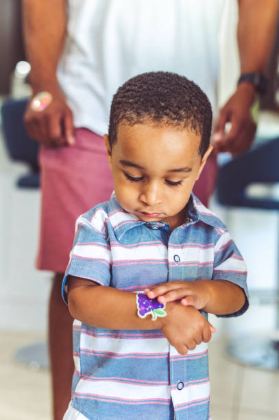 Cute African American toddler in a candid portrait with a sticker Adorable little boy, 2.5 years old at home with a sticker in a candid moment kid stickers stock pictures, royalty-free photos & images