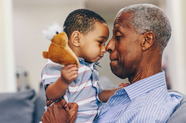 African American grandfather and grandson face to face Handsome toddler boy and his grandfather get face to face together in a candid moment of togetherness 80 89 years stock pictures, royalty-free photos & images