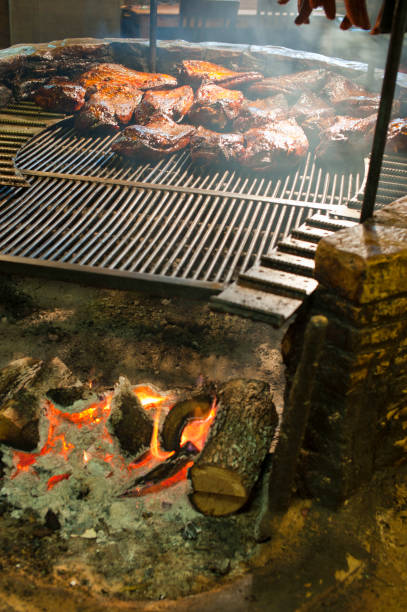 istock Barbecue meat. BBQ meat cooking on a BBQ pit. Barbecue table spread. Beef brisket, chicken, pork ribs, beef ribs, Mac n cheese, cornbread, Brussels sprouts, colesla. Classic meats & side dishes. 1265055266