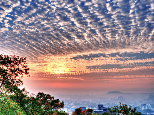 vista do nascer do sol em pune com um padrão de nuvens agradável e cores dramáticas. - parvati - fotografias e filmes do acervo