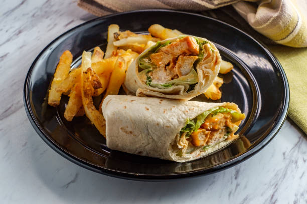 Buffalo Chicken Sandwich Wrap Grilled buffalo chicken sandwich wrap with romaine lettuce bleu cheese and fries african buffalo stock pictures, royalty-free photos & images