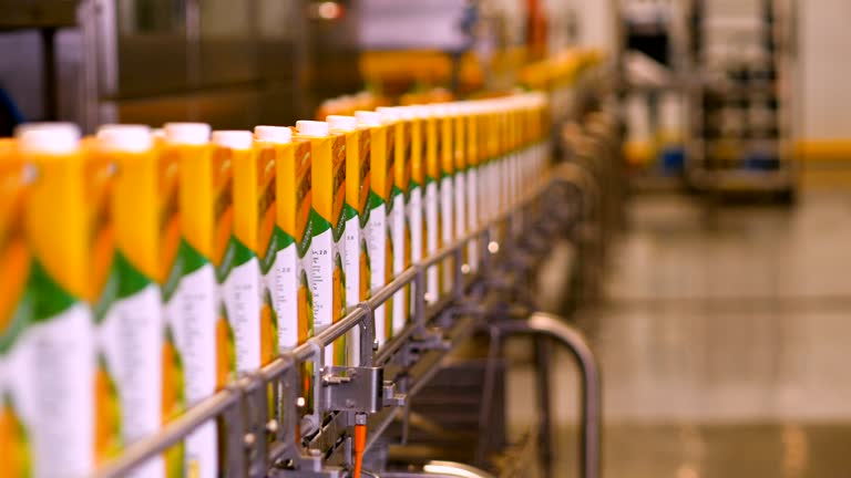 Factory for juice production. Distribution line for ready-made juice packages. Fruit and berry juice at the factory. Juices in packs. Side view