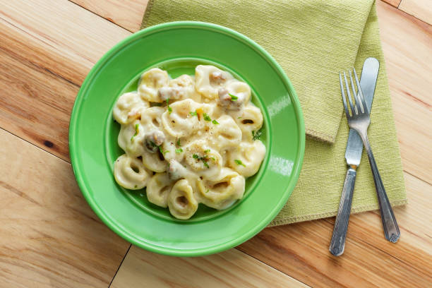 Butter and parmesan cheese tortellini alfredo with Italian sausage