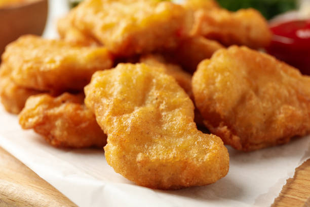 istock Fried chicken nuggets on wooden board, close up 1265061801