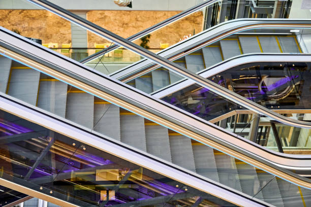 Crisscross escalators in shopping center. Empty escalators stairs up and down in office building, shopping mall or subway station.