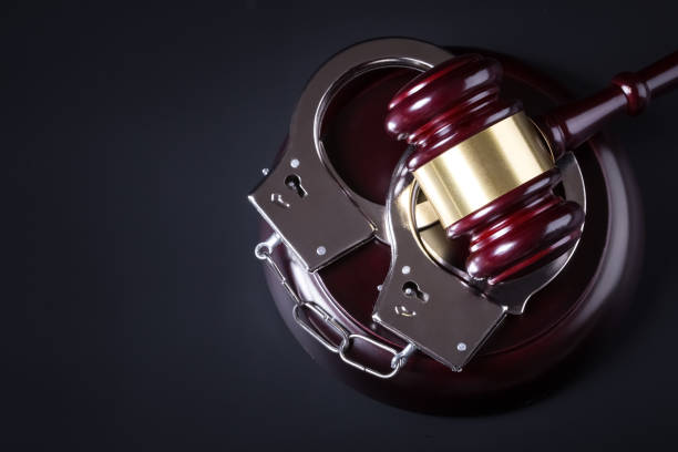 Wooden judge gavel and police handcuffs Wooden judge gavel and police handcuffs isolated on black background handcuffs stock pictures, royalty-free photos & images