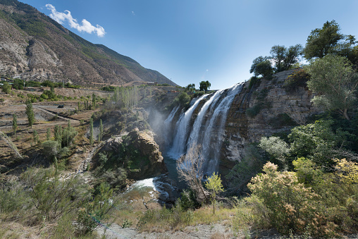 Tortum Waterfall in Erzurum - Turkey 28 August 2019 : Tortum Waterfall was formed by the pouring of Tortum Lake over the landslide mass in Tev Valley. It has a width of 21 meters and a height of 48 meters. The height of the waterfall and its surroundings is approximately 1000 meters above sea level. It was formed when the large landslide mass separated from Kemerlidağ in the 1700s closed the Tev Valley where the Tortum Stream flowed. It formed a giant cauldron where the waters of Tortum Waterfall fell. Today, a natural environment where water sports can be done has been created.