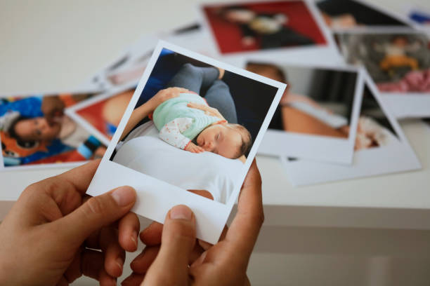 mano sosteniendo foto instantánea - bebé fotos fotografías e imágenes de stock
