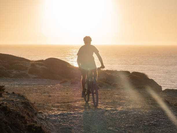 istock Mountain biker riding on the edge of a cliff at sunset 1265066878